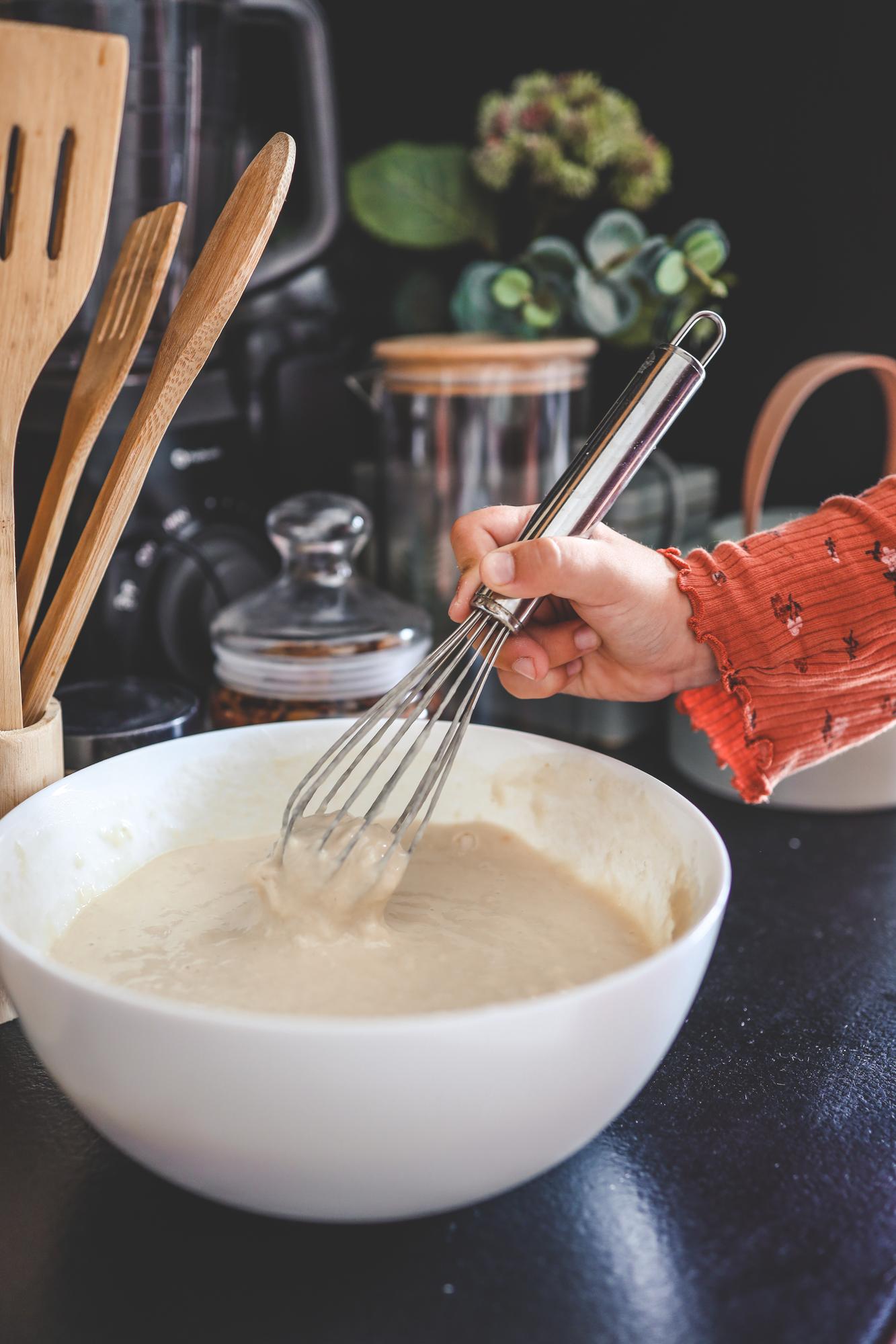Dettaglio mani che preparano una salsa cremosa
